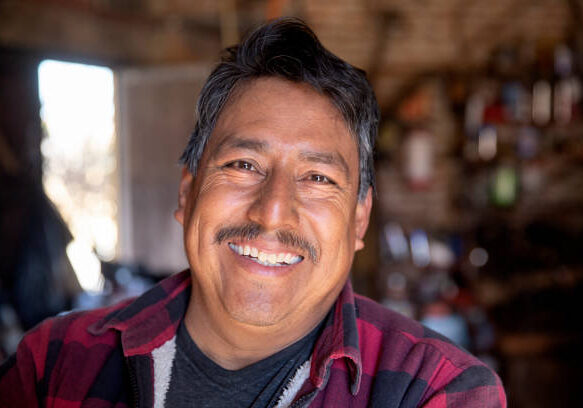 A smiling, friendly looking metal worker in his workshop